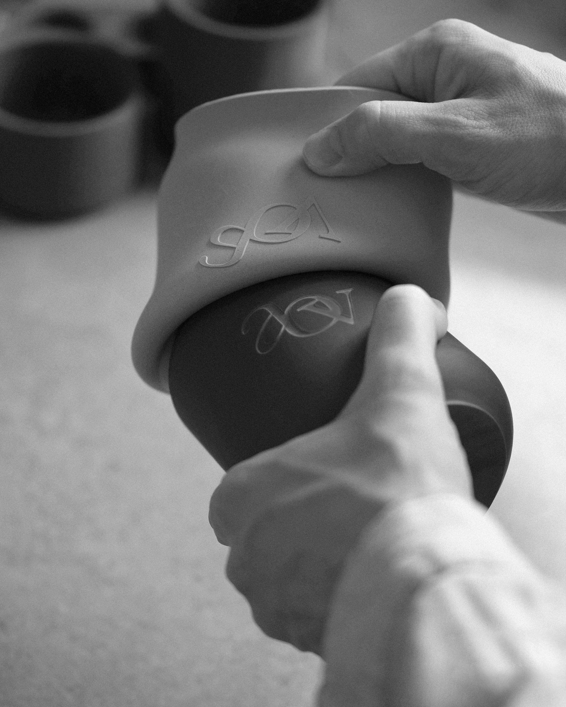 Person demolding a concrete candle vessel with a custom debossed logo from a silicone mold.